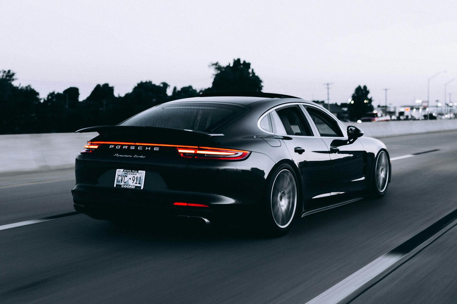 Black Porsche 911 on a wet street at dusk